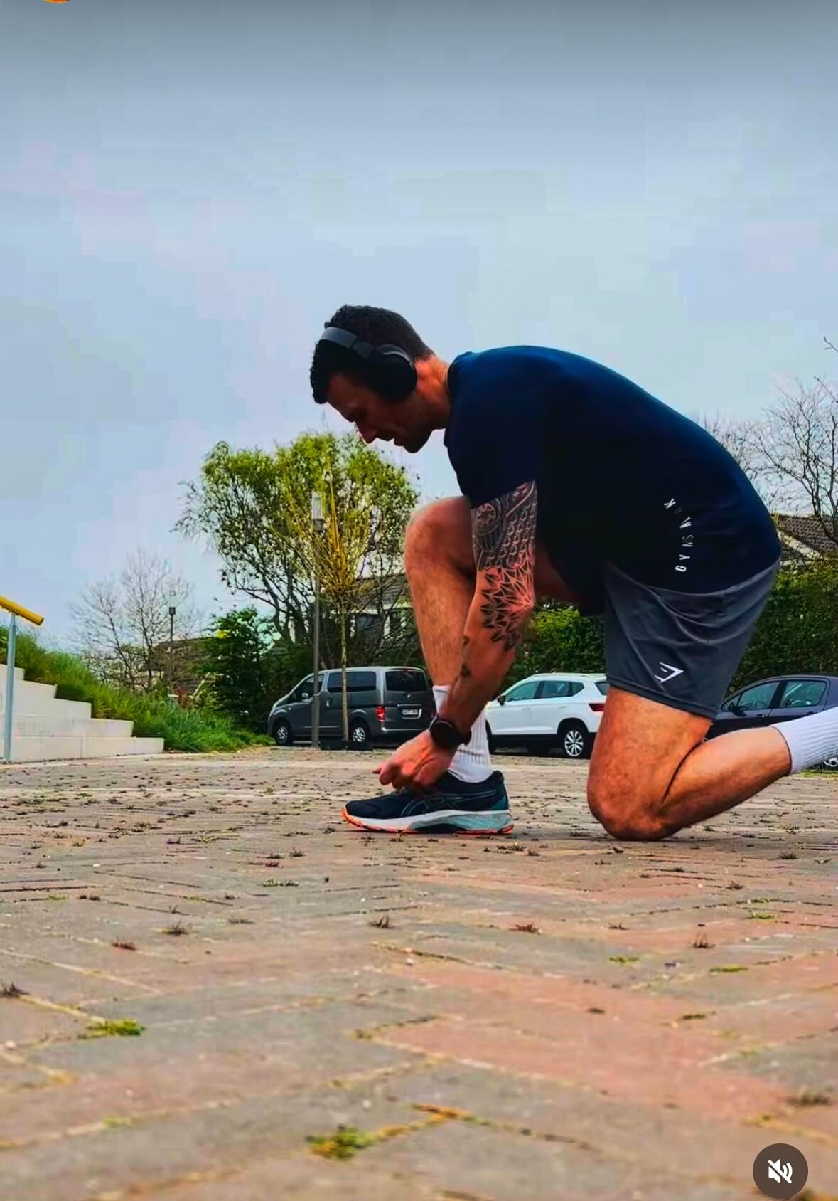 Fit by Yoeri | Coaching | Personal training Een foto van Yoeri vetersstrikkend voor het